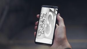 A hand holding a Samsung Galaxy S8 with the text opposing 5G.