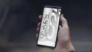 A hand holding a Samsung Galaxy S8 with the text opposing 5G.