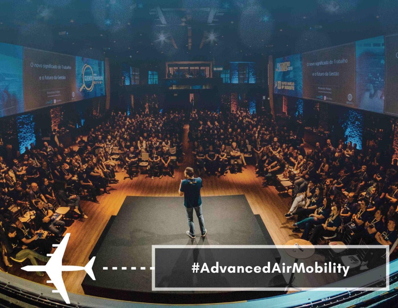 A man is standing on stage at the NDRC Summit in front of an audience with the words advanced air mobility.