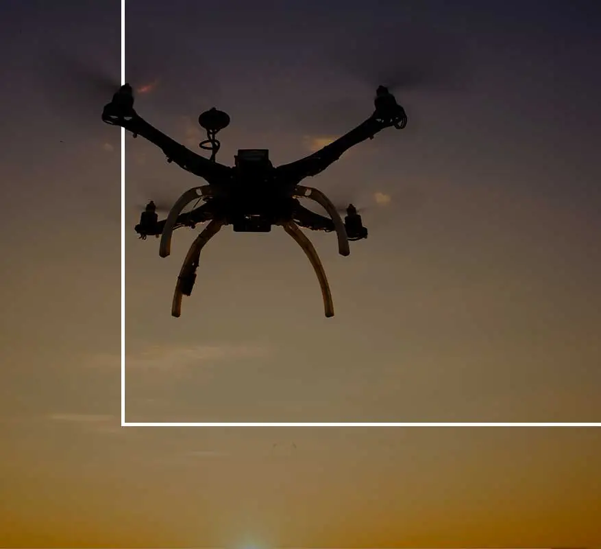 Drone silhouette against sunset sky.